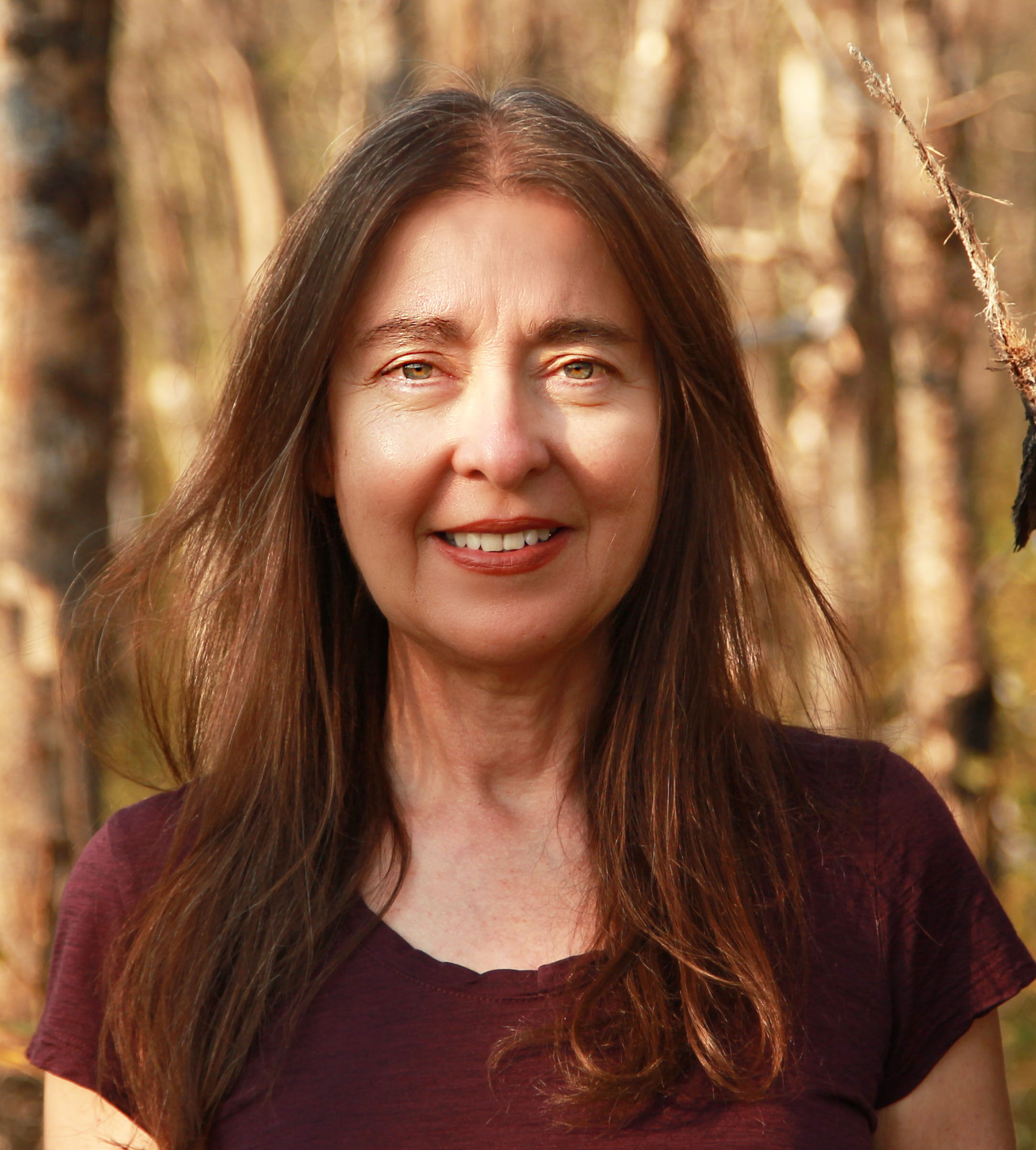 Dr. Christina Eisenberg, standing in a birch forest