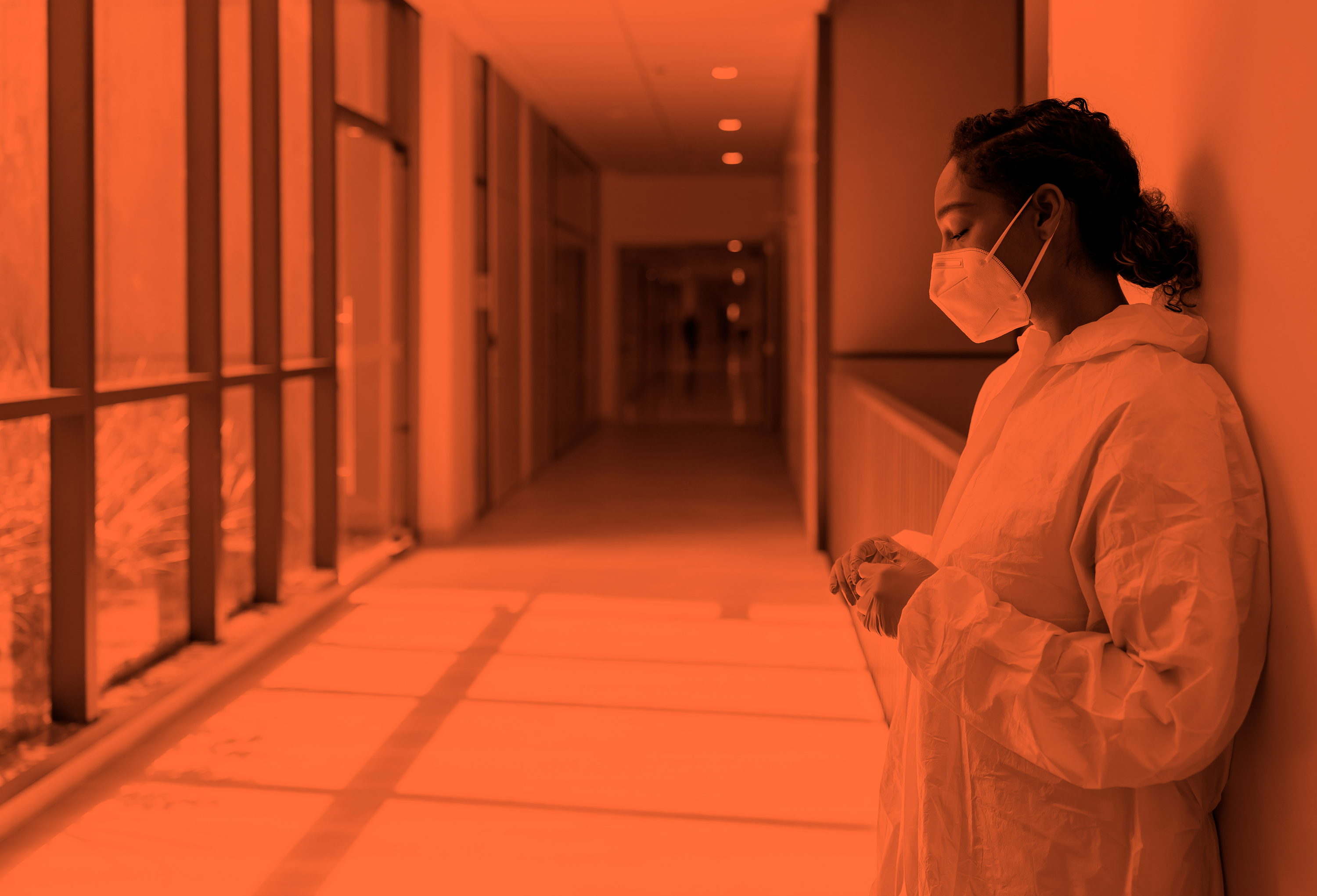 female doctor with a mask on in a hospital hallway